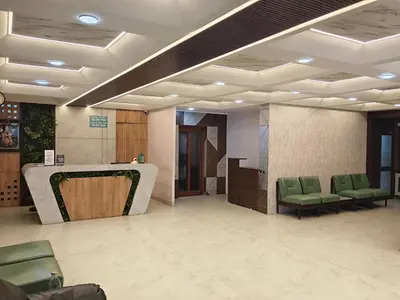 a waiting room with green chairs and a table at NavaRATNA Delight in Coimbatore