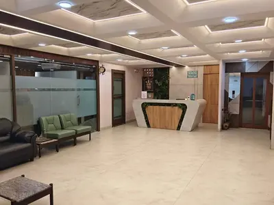 a lobby with chairs and a table in a building at NavaRATNA Delight in Coimbatore