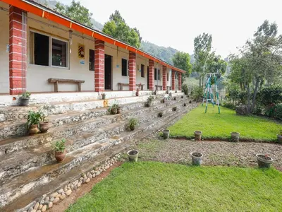 a house with a set of stairs in a yard at DEVASHOLA HOMESTAY in Coonoor