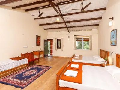 a large room with two beds and a couch at DEVASHOLA HOMESTAY in Coonoor