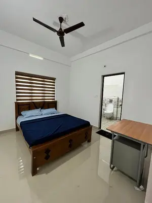 a bedroom with a bed and a ceiling fan at Wayanad Biriyomz Residency, Kalpatta, Low Cost Rooms and Deluxe Apartment in Kalpetta