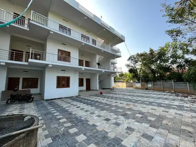 a large white building with a patio in front of it at Wayanad Biriyomz Residency, Kalpatta, Low Cost Rooms and Deluxe Apartment in Kalpetta