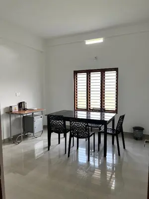 a dining room table and chairs in a room at Wayanad Biriyomz Residency, Kalpatta, Low Cost Rooms and Deluxe Apartment in Kalpetta