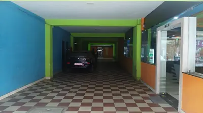 a hallway with a car parked in a building at PPH Living TriColours Hotel Gandhipuram in Coimbatore