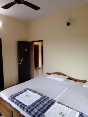 a bedroom with a bed with two towels on it at New Hill Valley Family Homestay-WiFi-View in Madikeri
