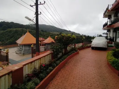 a car parked on a brick walkway next to a house at New Hill Valley Family Homestay-WiFi-View in Madikeri