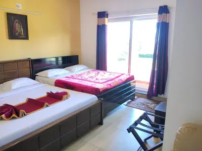 two beds in a small room with a window at Forest Gate only family in Ooty