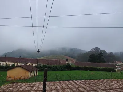 a view of a field with houses and a fence at Forest Gate only family in Ooty