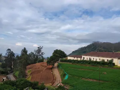 a view of a farm field and a house at Forest Gate only family in Ooty