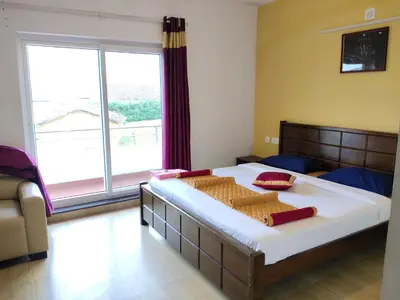 a bedroom with a large bed with a large window at Forest Gate only family in Ooty