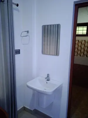 a white bathroom with a sink and a shower curtain at Mscb guest house in Idukki