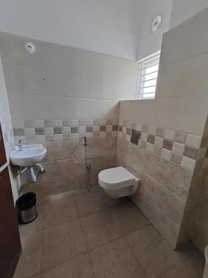 a bathroom with a toilet and a sink at Suyog Apartments in Mysore