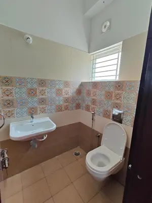 a bathroom with a toilet and a sink at Suyog Apartments in Mysore