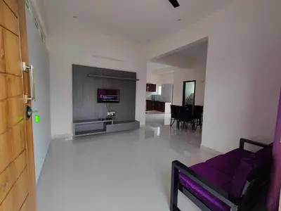a living room with a purple couch and a fireplace at Suyog Apartments in Mysore
