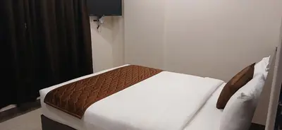 a bedroom with a bed with white sheets and a brown blanket at HOTEL PANKAJ RESIDENCY in Guruvāyūr