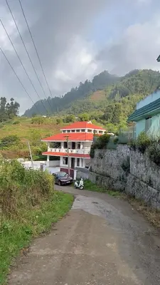 a building on a hill next to a dirt road at ATTUVAM VISTA in Kodaikānāl