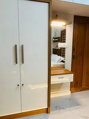 a bedroom with white cabinets and a bed in a room at Milaano Orchids, Service Villa, Kammana Mananthavady in Wayanad