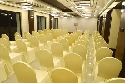 an empty room with white chairs and tables at The Zen Park Coimbatore in Coimbatore