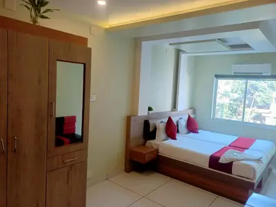 a bedroom with a large bed and a window at Royal Plaza Residency in Cheruppulasseri