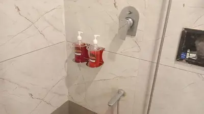 a bathroom with two bottles of coke on a wall at Coorg Vismaya in Madikeri