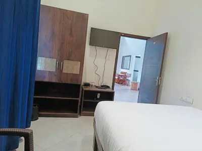 a bedroom with a bed and a door to a room at Coorg Vismaya in Madikeri