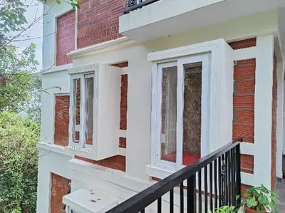 a balcony of a house with white windows at Coorg Vismaya in Madikeri