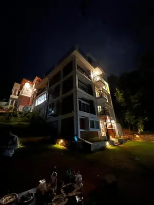 a large building with lights in front of it at night at Coorg Vismaya in Madikeri