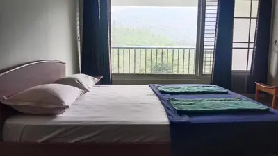 a bed in a room with a large window at Green Valley Holiday Home in Meppādi