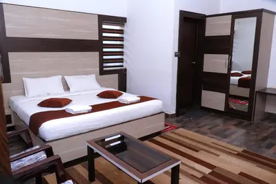 a bedroom with a large bed and a table at Cloud Nine Kothagiri By Lexstays in Kotagiri
