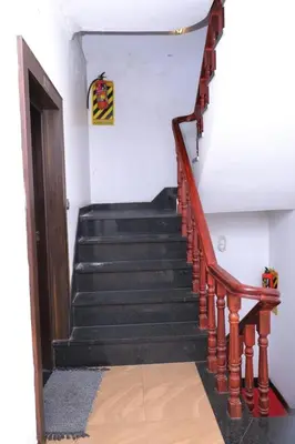 a stairway with a wooden railing and a stair case at Cloud Nine Kothagiri By Lexstays in Kotagiri