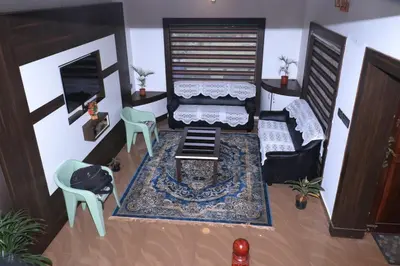 a living room with a couch and a table and chairs at Cloud Nine Kothagiri By Lexstays in Kotagiri