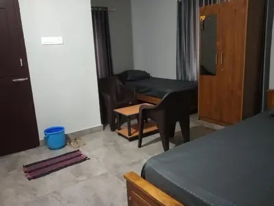 a room with a bed and a couch and a table at Malapuram quarters in Malappuram