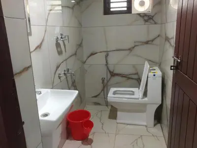 a bathroom with a white toilet and a sink at Malapuram quarters in Malappuram