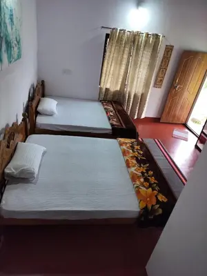 two beds in a room with a window at Madan Homestay in Napoklu