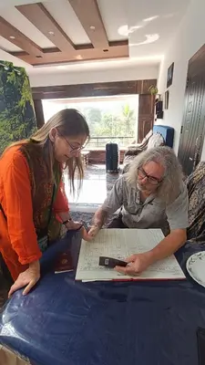 two women looking at a piece of paper on a table at Divine View Holyday Home (Homestay) in Kalpetta
