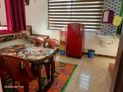 a dining room with a table and a red refrigerator at Divine View Holyday Home (Homestay) in Kalpetta