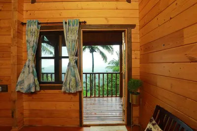an open door in a log cabin with a window at amã Stays & Trails The Malabar Villa Heliconia, Kozhikode in Wayanad