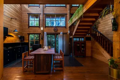 a kitchen with a large wooden table and chairs at amã Stays & Trails The Malabar Villa Heliconia, Kozhikode in Wayanad