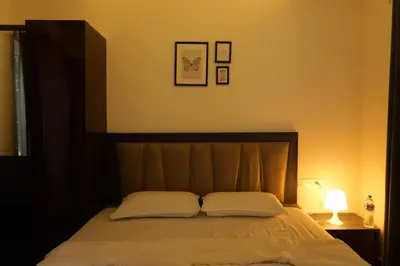a bedroom with a bed with two pillows on it at Royad Calicut Farm House - Premium Villa with Pool Inside a Farm in Kozhikode