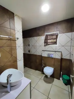 a bathroom with a sink and a toilet at Royad Calicut Farm House - Premium Villa with Pool Inside a Farm in Kozhikode