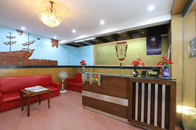 a waiting room with a red couch and a counter at Hotel O SK Regency in Mysore