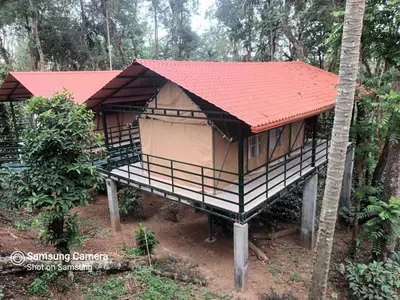 a small house with a red roof in the forest at Devi Villa - Plantation Retreat and Forest Getaway in Kutta