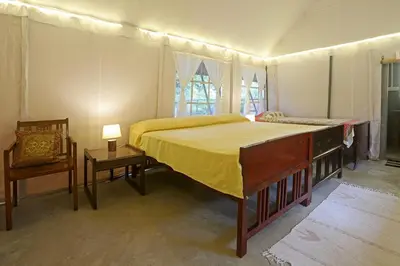 a bedroom with a bed and a dresser and a chair at Devi Villa - Plantation Retreat and Forest Getaway in Kutta