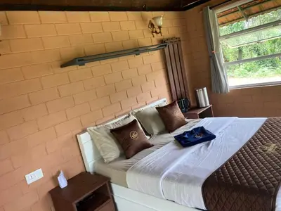 a bed with a blue bag on top of it at Fortune Clio Resort in Periya