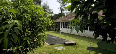 a building with a picnic table in the yard at Fortune Clio Resort in Periya