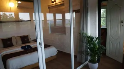 a bedroom with a bed and a glass door at Fortune Clio Resort in Periya