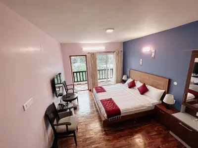 a bedroom with a large bed and a balcony at PURPLE ORCHID BY XACRO XPERIENCES in Kodaikānāl