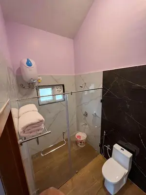 a bathroom with a shower and a toilet and a sink at PURPLE ORCHID BY XACRO XPERIENCES in Kodaikānāl