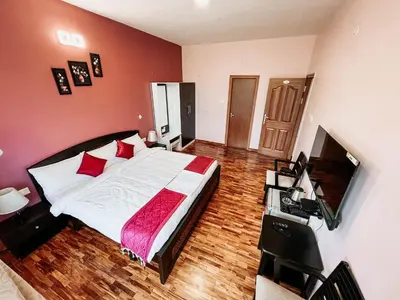 a bedroom with a large bed with red walls at PURPLE ORCHID BY XACRO XPERIENCES in Kodaikānāl