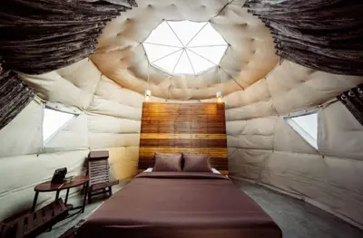 a bed in a room with a large window at PURPLE ORCHID BY XACRO XPERIENCES in Kodaikānāl